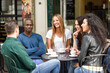 © javiindy - Multiracial group of five friends having a coffee together