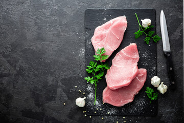 Poster - Raw meat, turkey steaks on black background, top view