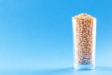 Corn Kernels In Glass On A Blue Background