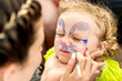 © sushytska - woman painting face of kid outdoors
