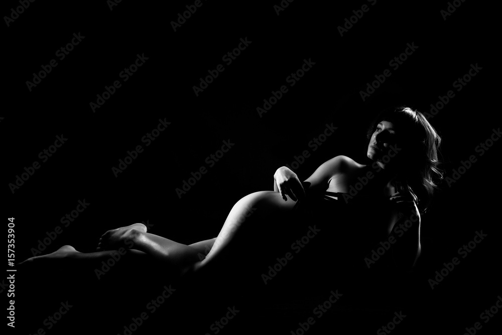 Naked woman sexy silhouette, sensual nude female body on a dark background. Black and White - obrazy, fototapety, plakaty 