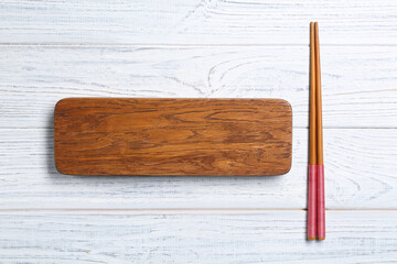 Canvas Print - Rectangular wooden board and chopsticks on table