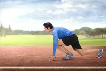 Poster - Young asian runner in start position ready to running