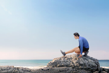 Poster - Portrait of asian fitness man stretching legs before jogging