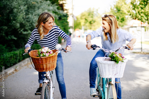 Fotografía Two young women exploring the city on bicycles
