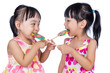 Leinwandbild Motiv Asian Little Chinese girls eating lollipop