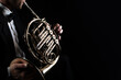 French horn instrument. Player hands playing horn music instrument