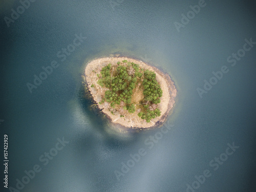 Zdjęcie XXL Idylliczny widok z lotu ptaka z zaciszną wyspą pośrodku jeziora bez widocznych granic linii brzegowej.