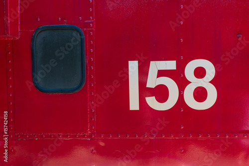 Fotografie, Obraz Red metal texture with window and 158 number from train side