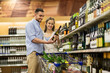 © Syda Productions - couple with wine and shopping cart at liquor store