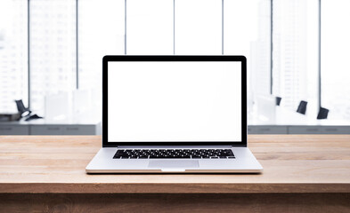 Wall Mural - Modern computer,laptop with blank screen on wood table with office window view background..