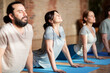 © Syda Productions - group of people doing yoga dog pose at studio