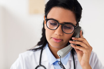 Sticker - doctor in glasses calling on phone at hospital