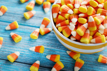 Halloween Candy Corns In Bowl On Blue Wooden Background