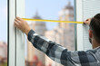 © Africa Studio - Young man taking measure of window for blinds installation at home
