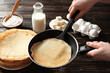 Woman cooking Russian pancakes in kitchen, closeup