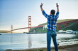 © Joshua Resnick - cool guy cheering and making peace sign in front of golden gate bridge in san francisco