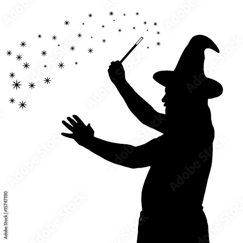 Fotomural Silhouette of bearded wizard in cloak with pointed hat creating magic