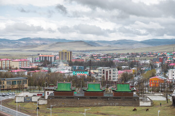 cows grazing near building Guden Sum with city landscape on background
