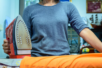 Woman ironing clothes in home