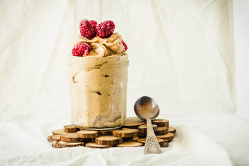 Wall Mural - Healthy chocolate banana ice cream, raspberries in a glass jar