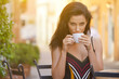 © ZoomTeam - Young woman having italian breakfast with croissant and coffee at the cafe on the street