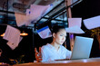 © LIGHTFIELD STUDIOS - thoughtful asian businesswoman working on laptop and throwing documents