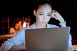 © LIGHTFIELD STUDIOS - young pensive asian businesswoman working on laptop while sitting at table