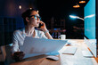 © LIGHTFIELD STUDIOS - Young businesswoman in eyeglasses holding blueprint and talking on smartphone