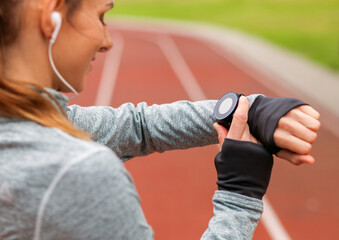 Sticker - Athletic woman on running track setting up her smart watch fitness accessories