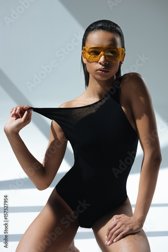 Fotografie, Obraz african american stylish model in black swimsuit and protective goggles posing o