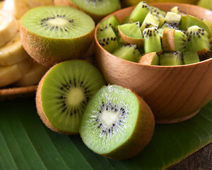 Poster - Kiwi fruit cut in wooden bowl on green background