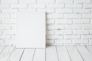 Wall Mural - Empty white canvas frame on a wooden table