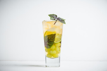 Fresh cocktail with grape, lime and basil leaves. Shallow depth of field.