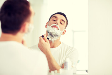 Poster - man shaving beard with razor blade at bathroom