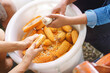 © bonnontawat - Worker Woman's hands holding a corn cob and separating the grains
