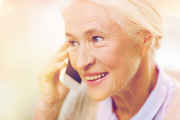 Wall Mural - senior woman with smartphone calling at home