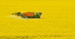 Tractor spraying rape field