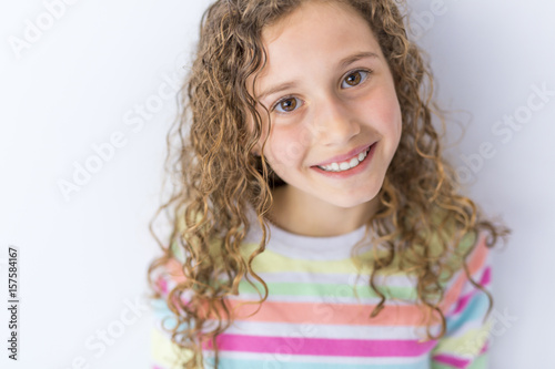 Portrait Of 9 Years Old Girl With Curly Hair Isolated On Gray