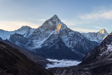 Wall Mural - ama dablam mountain at sunrise and blue sky. sun illuminates slopes. himalayan mountains, nepal.