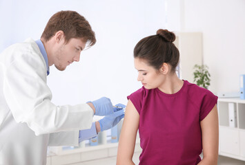 Sticker - Young woman receiving injection from medical assistant in clinic