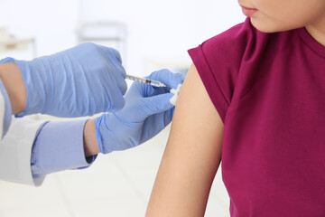 Poster - Young woman receiving injection from medical assistant in clinic, closeup