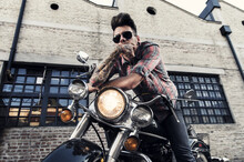 Tattooed Cool Young Man With Sunglasses Sitting On Vintage Motorcycle  