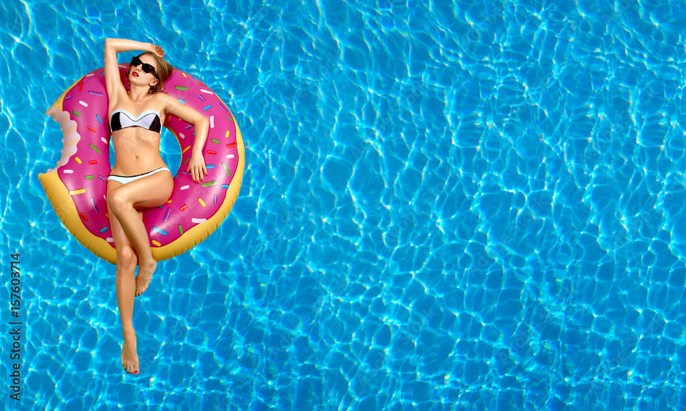 Woman in bikini on the inflatable mattress in the swimming pool. - obrazy, fototapety, plakaty 