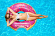 © Dmytro Flisak - Woman in bikini on the inflatable mattress in the swimming pool.
