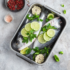 two raw dorado fish with lime and parsley ready to cooking