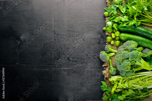 Stampa su Tela Collection of fresh green vegetables placed on black stone