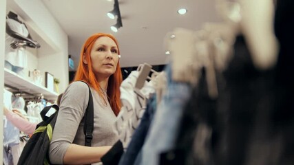 Wall Mural - The girl is buying a dress in women's clothing store