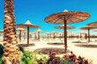 Chaise lounges and parasols on the beach against the blue sky and sea. Egypt, Hurghada