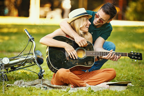 Plakat Miłości para korzystających gitara w parku